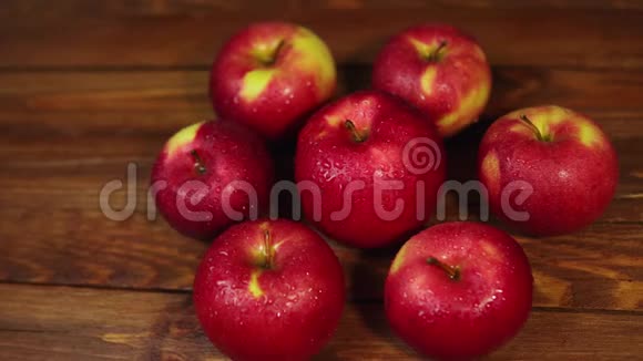 一堆红色的开胃苹果放在深色的木桌上视频的预览图