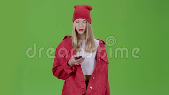 年轻时尚的女孩走在街上打电话绿色屏幕视频的预览图