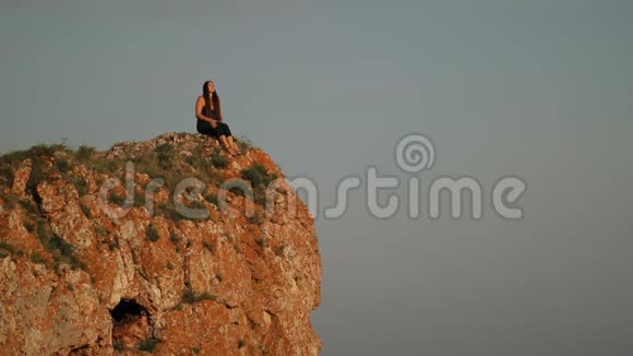 坐在山顶上的年轻女子视频的预览图