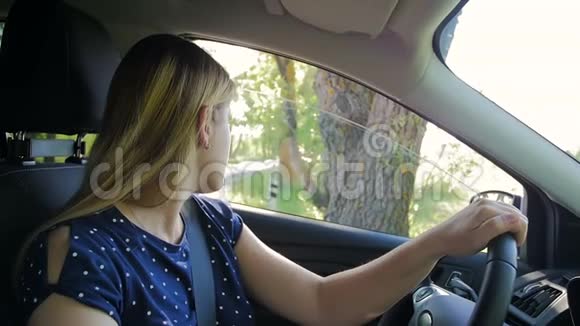 年轻女子倒车和上路的慢镜头司机看侧视镜视频的预览图