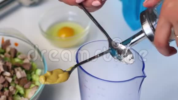 带有蔬菜和蛋黄酱的俄罗斯肉沙拉女人把芥末和糖加到搅拌机的玻璃上做成蛋黄酱视频的预览图