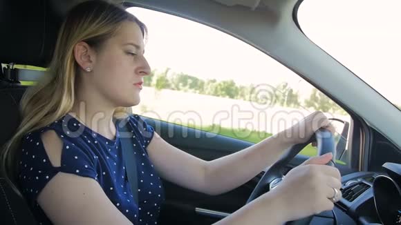 慢镜头拍摄的年轻女子在开车时感到很累睡着了视频的预览图