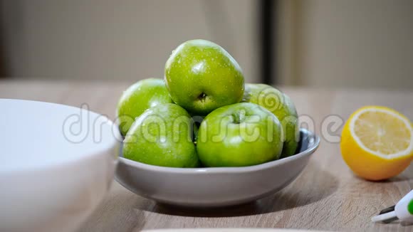 从厨房的水果碗里拿一个新鲜的绿苹果的女人视频的预览图