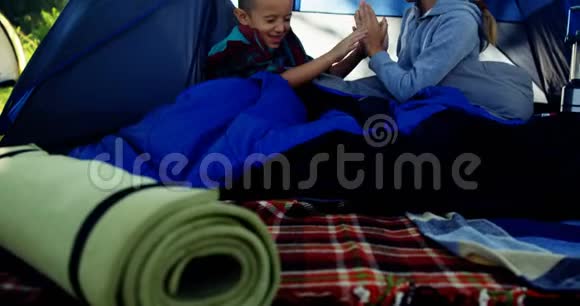 小兄弟在帐篷外面玩视频的预览图