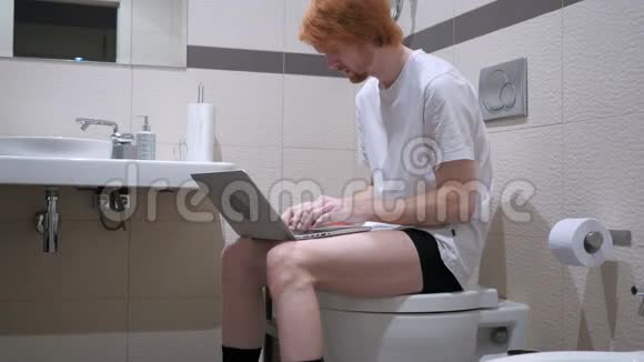 头痛疲惫的男人在浴室里用笔记本电脑视频的预览图