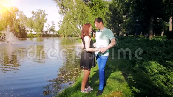 在河岸上拥抱美丽年轻夫妇的慢动作视频视频的预览图