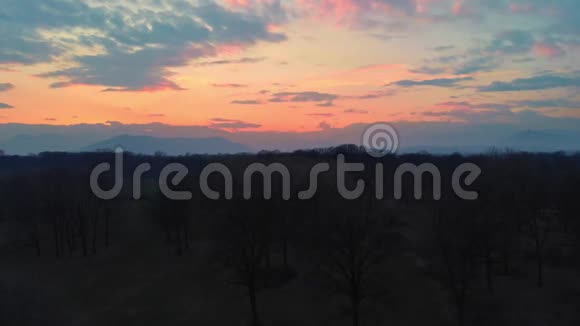 空中从上面飞过乡村森林林地和自然公园日落多彩的天空飞过阿尔卑斯山皮埃蒙特意大利视频的预览图