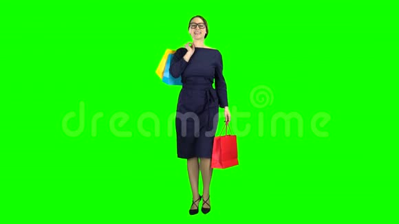 手里拿着购物包的女孩正沿着街走绿色屏幕视频的预览图