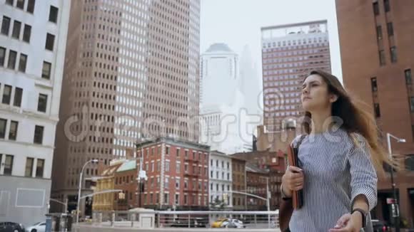 年轻漂亮的女商人拿着文件步行去纽约金融区工作慢动作视频的预览图