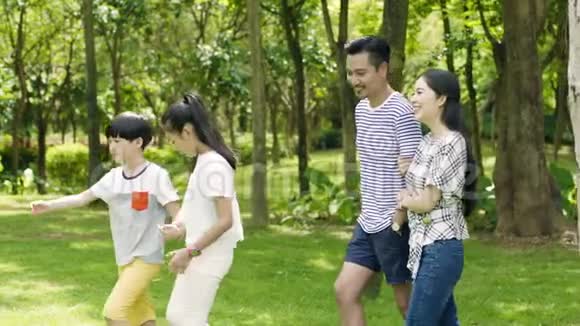 在阳光明媚的夏天4岁的亚洲家庭在公园里散步和欢笑视频的预览图