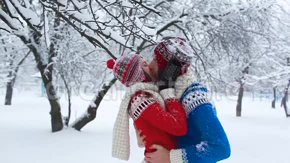 快乐的一对恋人在冬天玩拥抱和亲吻视频的预览图