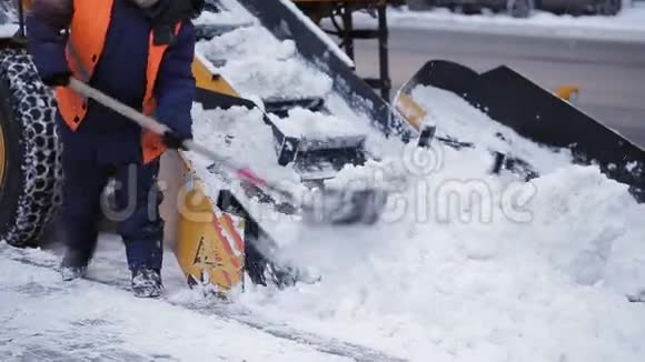 拖拉机从雪地上清理道路挖掘机清扫城市大量积雪的街道工人清扫视频的预览图