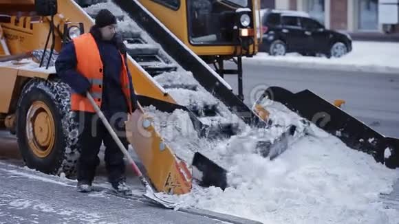拖拉机从雪地上清理道路挖掘机清扫城市大量积雪的街道工人清扫视频的预览图