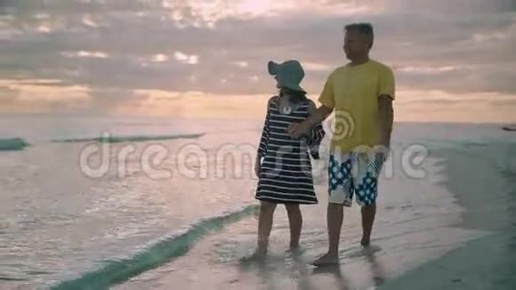 可爱的夫妇在月光下漫步在海滩上视频的预览图