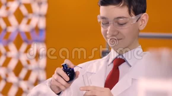 一个男孩科学家计算蓝色的水滴从一个烧瓶掉进玻璃管4K视频的预览图