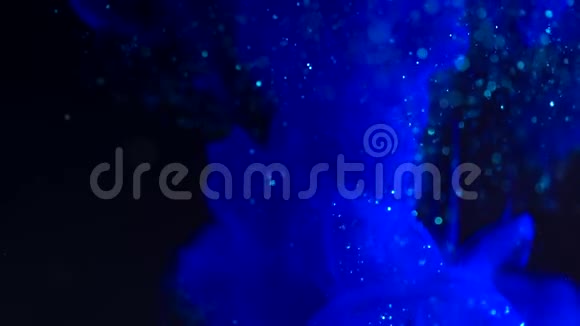 墨水在水里蓝色闪光颜料在水中反应产生抽象的云层可用作过渡视频的预览图