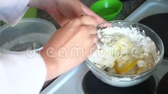 那个女人把面团揉成玻璃容器一个女人正在准备煎饼的面团视频的预览图
