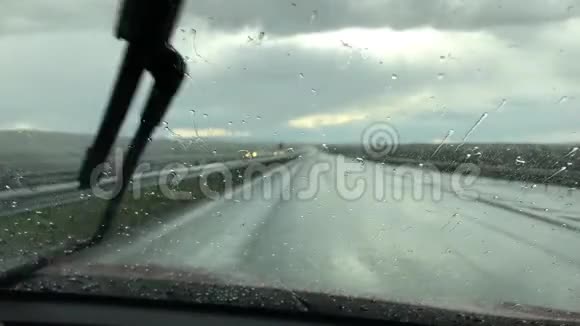 雨点落在汽车挡风玻璃上透过车窗可以看到雨天的景色雨季概念视频的预览图