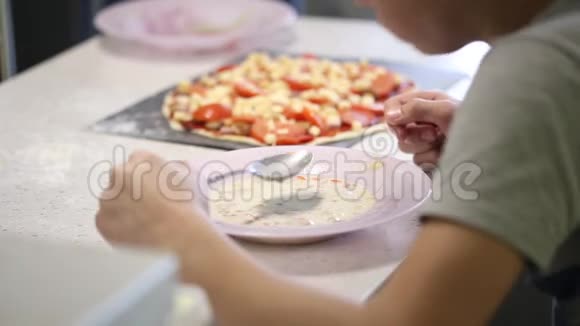 一个少年用盘子里的勺子吃汤视频的预览图
