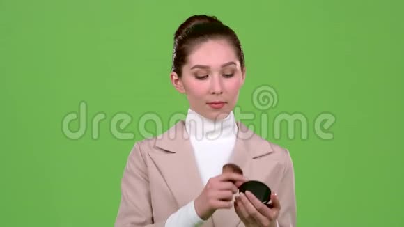 女人被涂上油漆用刷子放粉然后照镜子绿色屏幕视频的预览图
