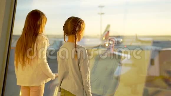 孩子们一起在机场等候登机靠近大窗户视频的预览图