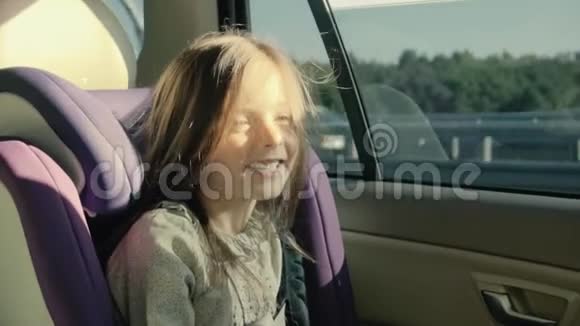 害羞的女孩坐在车里微笑着开始快乐地笑她喜欢在懒汉生活视频的预览图
