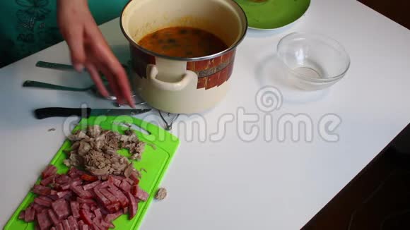 女人把煮好的肉倒进肉汤里汤盐汁烹饪用的材料在桌子上视频的预览图