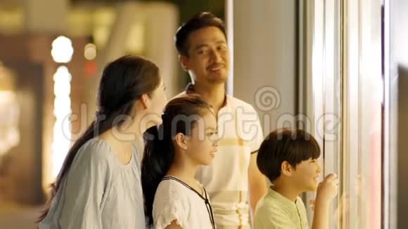 亚洲家庭4人站立缓慢地看着橱窗视频的预览图