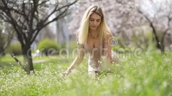 一个年轻的女人快乐享受春天的花朵视频的预览图