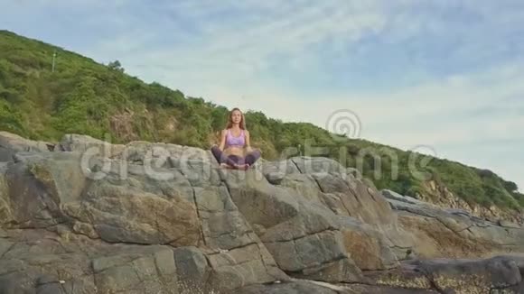 金发女孩坐在瑜伽姿势中放松对青山视频的预览图