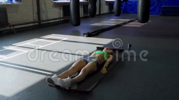 运动垫上的女运动员在健身房做腹肌锻炼肌肉女运动员做腹肌锻炼视频的预览图