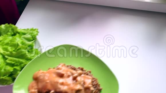 这个人在桌子上放了一个现成的荞麦菜里面有蒜泥和生菜叶视频的预览图