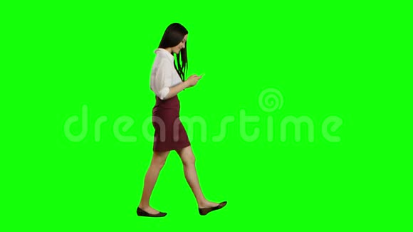 亚洲女孩走在街上手机看着有趣的照片绿色屏幕视频的预览图