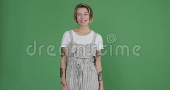 绿色背景下的快乐纹身女人视频的预览图