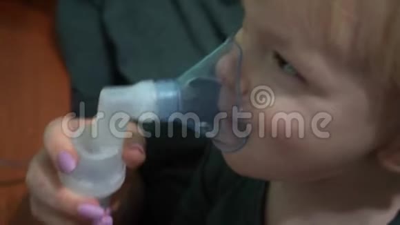 三岁的孩子戴着氧气面罩呼吸吸入呼吸道面罩吸入器视频的预览图