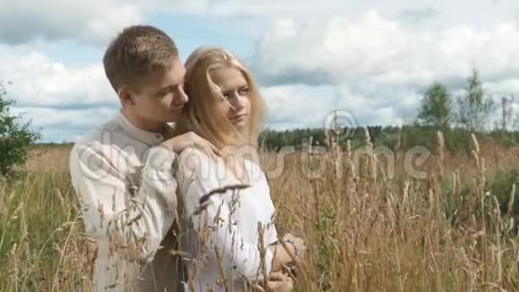 年轻的金发女人和她的男朋友正在田野上抱着小麦视频的预览图