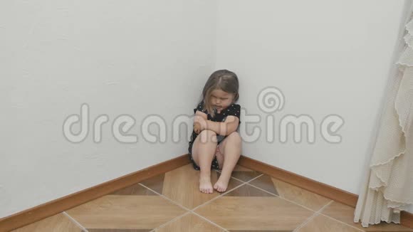 悲伤的小女孩眼睛附近有瘀伤坐在地板上拥抱自己视频的预览图