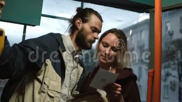 男人和女人从盒子里拿着卡片读着什么晚上在电车里拥抱的年轻夫妇视频的预览图