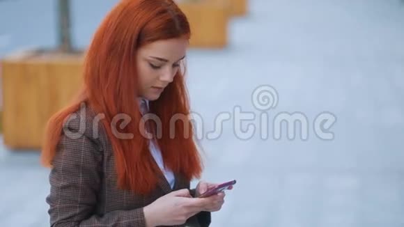 红发美女模特的侧景她穿着棕色夹克和白色t恤双手温柔视频的预览图