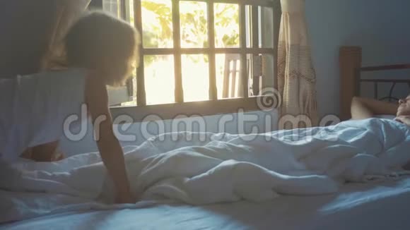 可爱的小女儿在早晨缓慢地叫醒她的母亲视频的预览图
