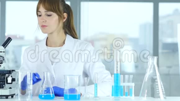在实验室工作的女科学家在试管中倒入化学溶液视频的预览图