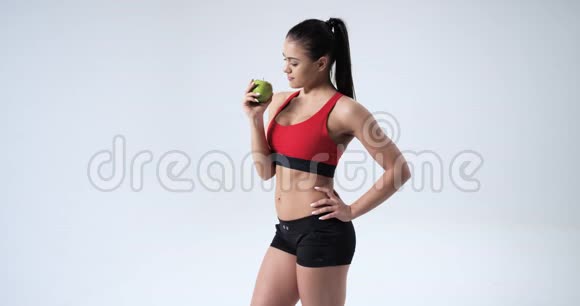 年轻的健身女人手里拿着苹果微笑健康的生活方式慢动作红色史诗4k视频的预览图