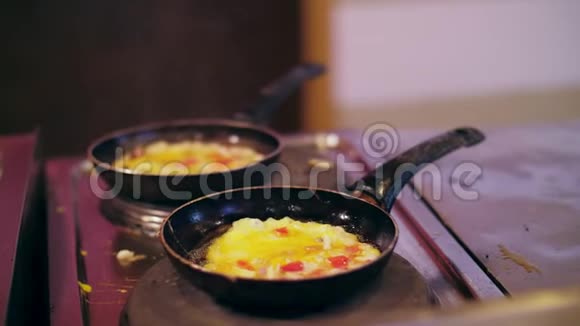 小牛肉煎鸡蛋在炉子上用两个油腻的脏的平底锅煮熟炉子也很脏在平底锅上你可以看到视频的预览图