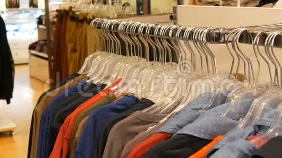 商场或购物中心的服装店里挂在衣架上的各种多色服装视频的预览图