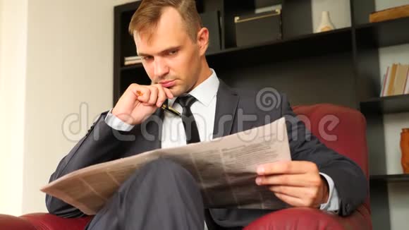 这位商人坐在椅子上看报纸他不快乐富有表现力4慢动作视频的预览图