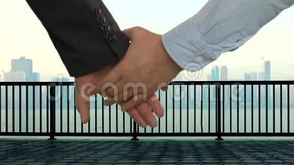 商业夫妻牵手河有栏杆的码头有摩天大楼的市中心视频的预览图