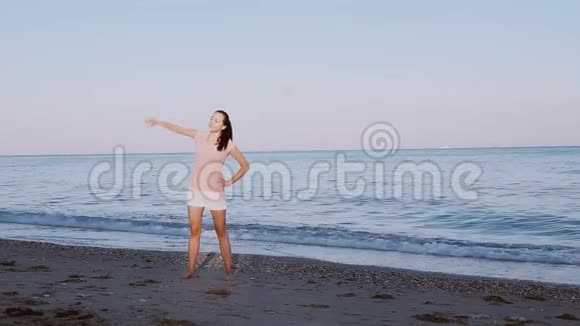 在海边海滩上做早操的漂亮女孩视频的预览图
