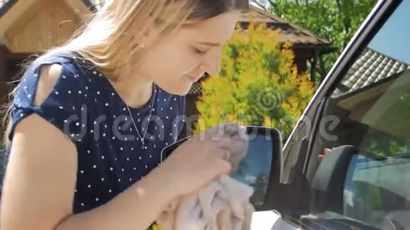 4k特写镜头年轻女司机用布清洁汽车侧镜视频的预览图