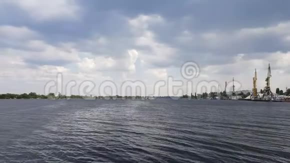 多云的天空和河流中的城市景观和天际线阳光蓝天丹妮珀河港口的集装箱起重机装卸视频的预览图