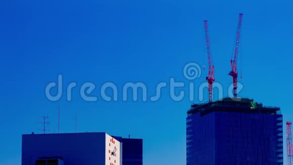 东京蓝天后面建筑顶部的起重机移动的时间间隔视频的预览图